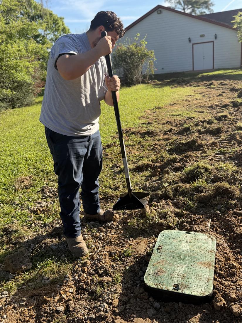 Tech tamping soil around a new valve box